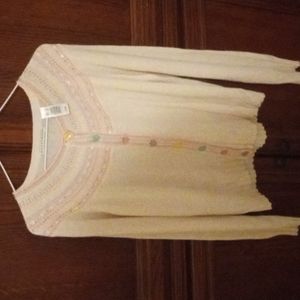 This beautiful sweater is embellished all in the front with pretty flower button